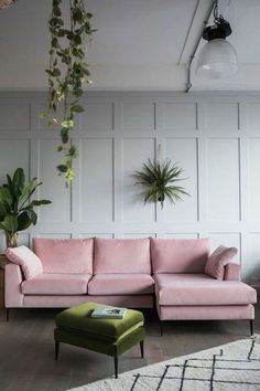 a living room with pink couches and potted plants