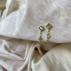 Evie 14K Gold Plated Sterling Silver Green Peridot Studs Never loose your back with these babies! Made with a gorgeous figaro chain these little cuties shine bright by themselves but also pair perfectly with almost any other earring. Made with handpicked green Peridot the top stud is a diamond Peridot leading down to a round shaped Peridot both sitting on the figaro chain which then wraps around the earlobe to the backing. Peridot set in gold is said to develop its full potential as a talisman. * Pretty and petite Studs * High quality 2 micron 14K gold plating to premium jewellery standards * High quality Sterling Silver * Lead & Nickel free * Each Topaz has its own natural sheen so your piece is practically a one of a kind! * Also available in Sterling Silver Peridot is one of the most an Leo Birthstone, Green Stud Earrings, Printed Canvas Bag, Peridot Earrings, Figaro Chain, Earrings Green, Stone Studs, Green Peridot, Green Earrings