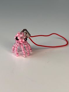 a pink beaded toy holding a red cord