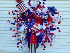 a patriotic wreath with red, white, and blue decorations on the side of a building