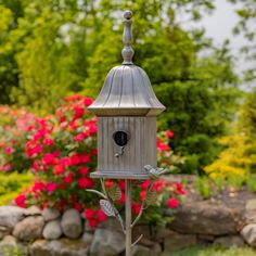 a bird house in the middle of a garden