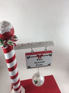 a red and white striped pole with a sign on it that says the north pole