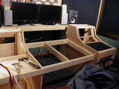 the desk is made out of plywood and has two monitors on each side with wires running through them