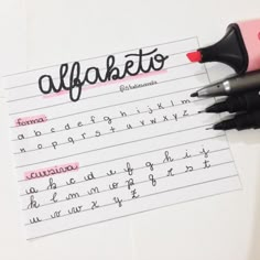 two black and pink pens sitting on top of a piece of paper