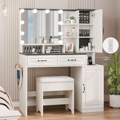 a white vanity with lights on it and a mirror in the corner next to a bed