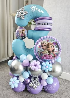 a birthday cake made out of balloons and other items for a frozen princess themed party