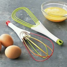 eggs, whisk, and other kitchen utensils on a gray surface