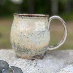 a coffee cup sitting on top of a rock