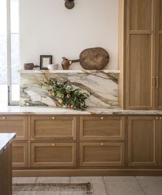 a kitchen with marble counter tops and wooden cabinets