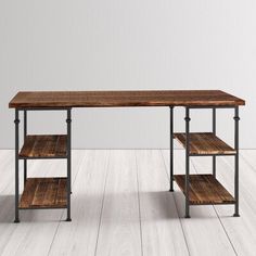 a wooden table sitting on top of a hard wood floor next to a white wall