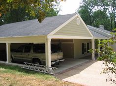 a car is parked in front of a two car garage with an attached carport