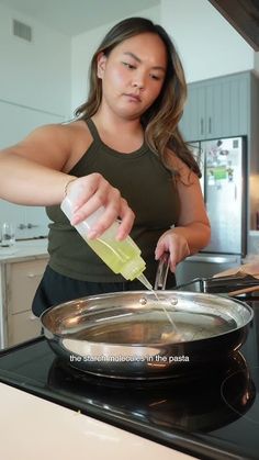 a woman is pouring something into a pan on the stove