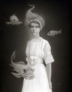 a black and white photo of a woman in a dress with fish around her neck