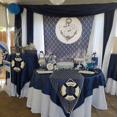 a table set up with blue and white decorations for a nautical themed baby shower party