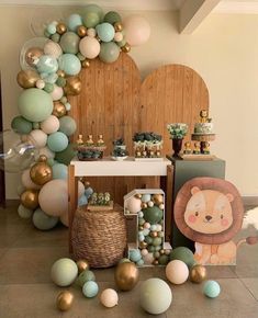 a party with balloons and decorations on the floor, including an animal balloon arch in pastel colors