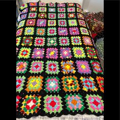 a crocheted granny blanket is displayed on a bed