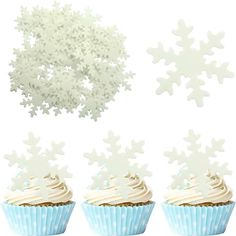 three cupcakes with frosting and snowflakes on top are shown in front of a white background