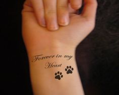 a woman's arm with a tattoo that says forever in my heart and paw prints