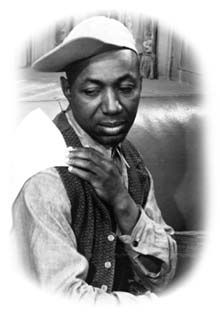 a black and white photo of a man wearing a hat holding something in his hands