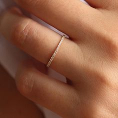 a woman's hand with a diamond ring on her left hand and the middle finger