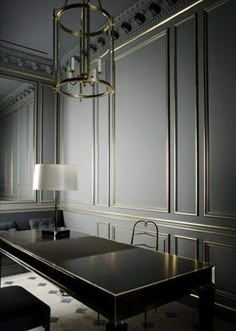 an elegant dining room with gold trimming and chandelier above the long table