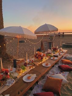 a table set up on the beach for an outdoor dinner