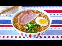 a bowl filled with rice and meat next to chopsticks on top of a table