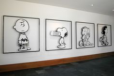 a wall with three framed cartoon pictures on it