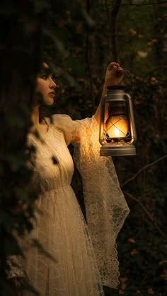 a woman holding a lantern in the woods