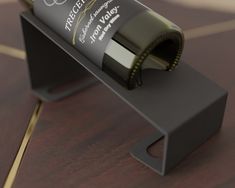 a bottle of wine sitting on top of a wooden table next to a metal holder