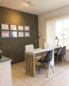 a dining room table with chairs and pictures on the wall