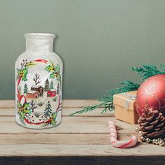 a glass vase sitting on top of a wooden table next to christmas decorations and candy canes