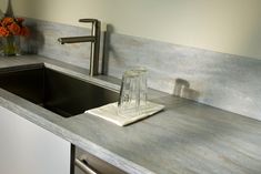 a kitchen counter with a sink, faucet and soap dispenser