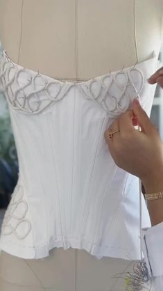 a woman is working on a wedding dress