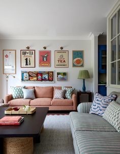 a living room filled with furniture and pictures on the wall above it's coffee table