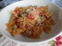 a white bowl filled with pasta and meat