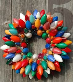 a wreath made out of colorful glass beads on a wooden fence with no people around it