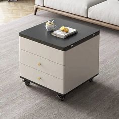 a coffee table with two drawers on wheels in the middle of a living room area