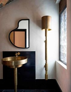 a bathroom with a gold sink and mirror