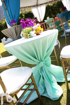 the table is set up with chairs and flowers