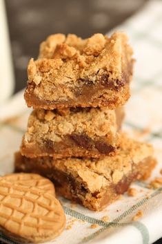 three pieces of cookie bars stacked on top of each other next to a glass of milk