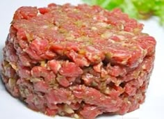 a square piece of meat sitting on top of a white plate