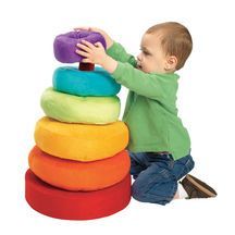 a young boy playing with a pile of pillows on top of a white sign that says price drop $ 5