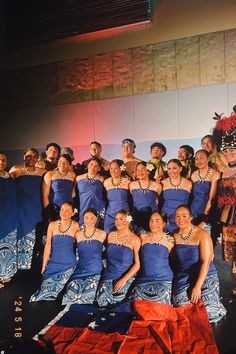 a group of women in blue dresses posing for a photo