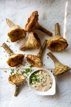 some fried food on a white towel with dipping sauce in the middle and other foods around it