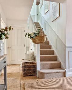 there is a basket with flowers on the bottom of some stairs in front of a set of stairs