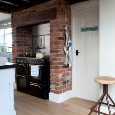 a kitchen with an oven, counter and stools