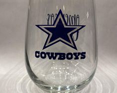 a wine glass with the word cowboys written on it and a star in the middle