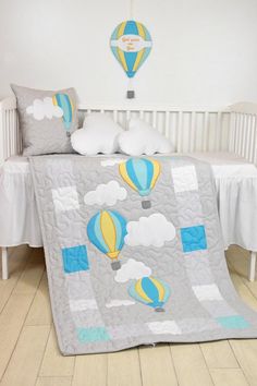 a crib bed with a quilted hot air balloons on it