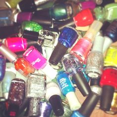 there are many different nail polishes on the table and one is full of them